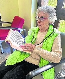 Una mujer lee con ayuda de una lupa convencional de alta graduación. Al lado, la lupa electrónica que transforma el texto en voz.