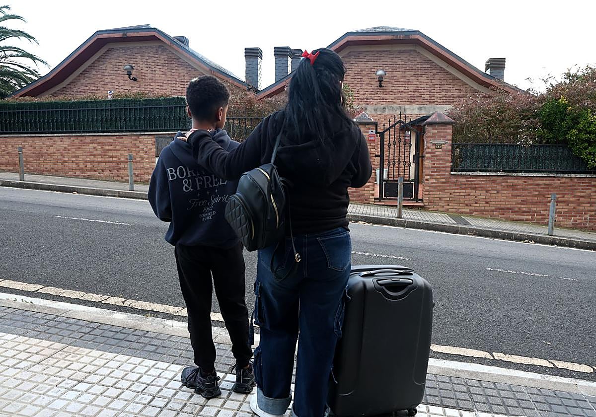Una de las mujeres afectadas por el desahucio observa la casa junto a su hijo menor de edad.