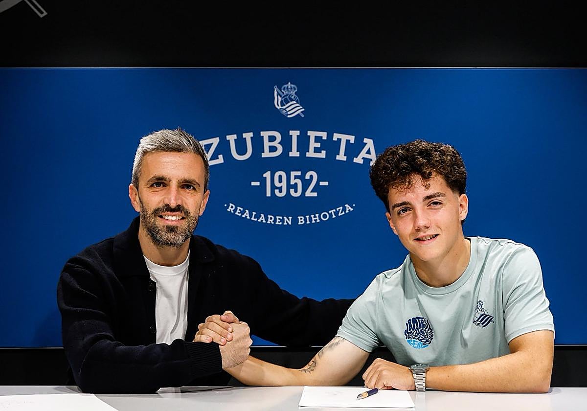 Dani Díaz, a la derecha, estrecha la mano del director de fútbol de la Real Sociedad, Erik Bretos, tras renovar hasta 2029