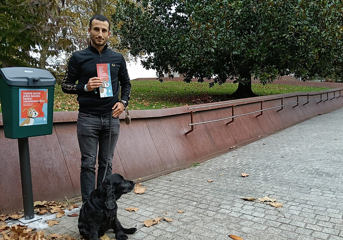 El concejal de Participación, Aitor Lukas, mostrando el decálogo junto a un contenedor para los excrementos.