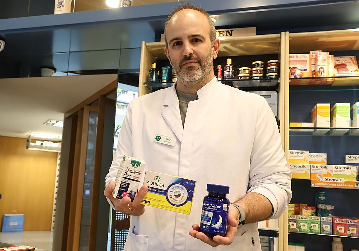 El farmacéutico Iñaki Ausan sostiene entre sus manos varios productos con melatonina que vende en su farmacia del barrio donostiarra de Amara.