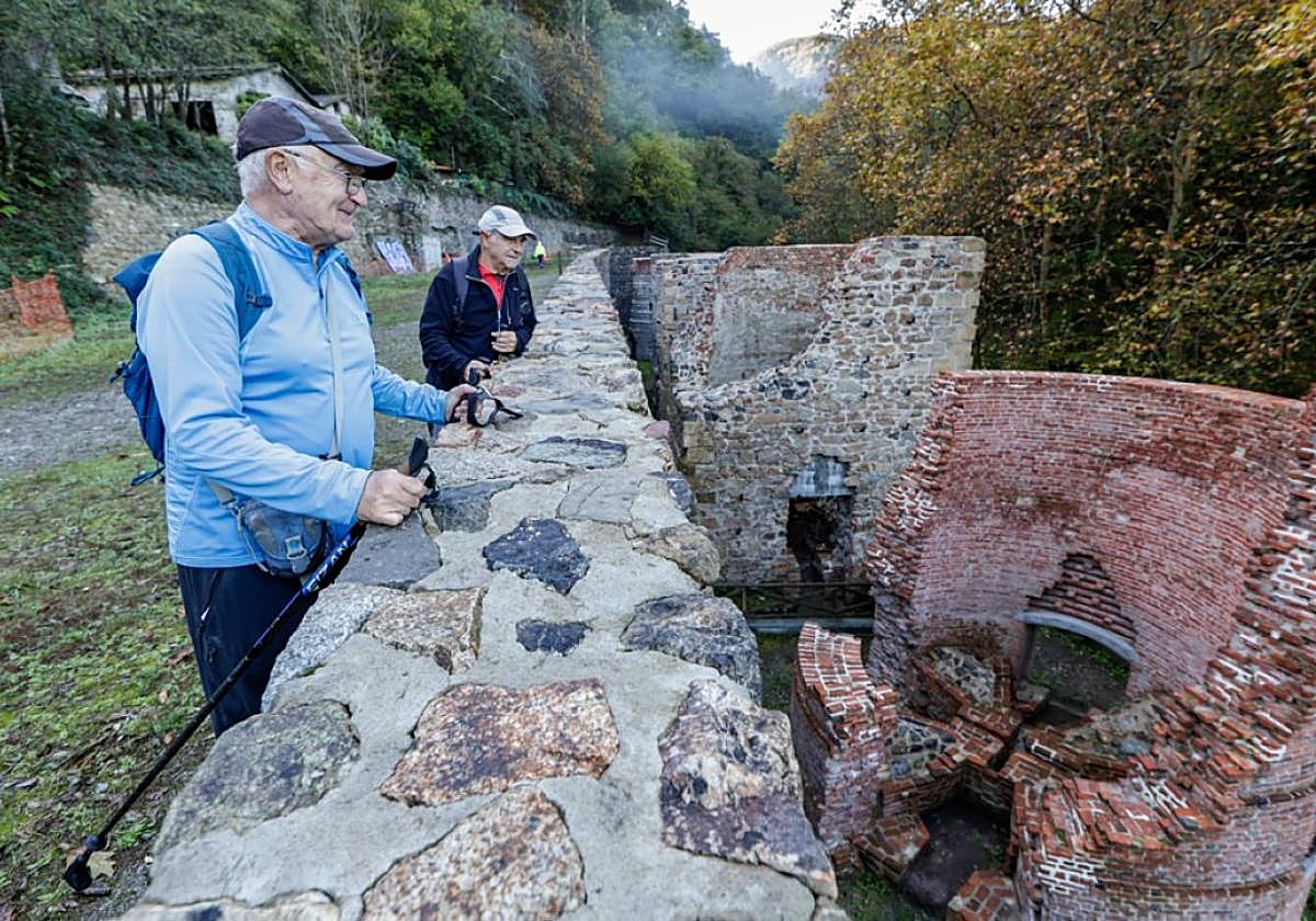 Senderistas observan los vestigios de los hornos de calcinación.