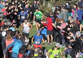 Decenas de personas animan a un grupo de atletas en el tramo final de la ascensión a Karakate de 2023.