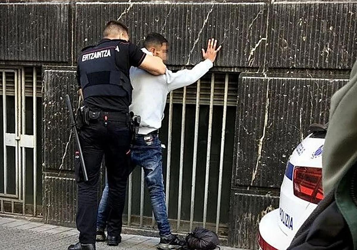 Un agente de la Ertzaintza registra a un delincuente, en Bilbao