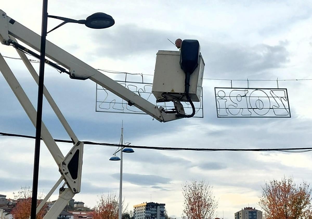 Un operario municipal instala alumbrado de Navidad en Azkuene.