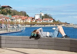Una mujer se tapa del sol este domingo en Zumaia.