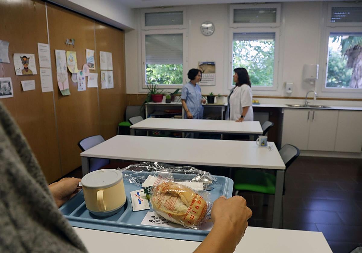 Una paciente sujeta una bandeja de comida en el comedor terapéutico del Hospital Donostia.