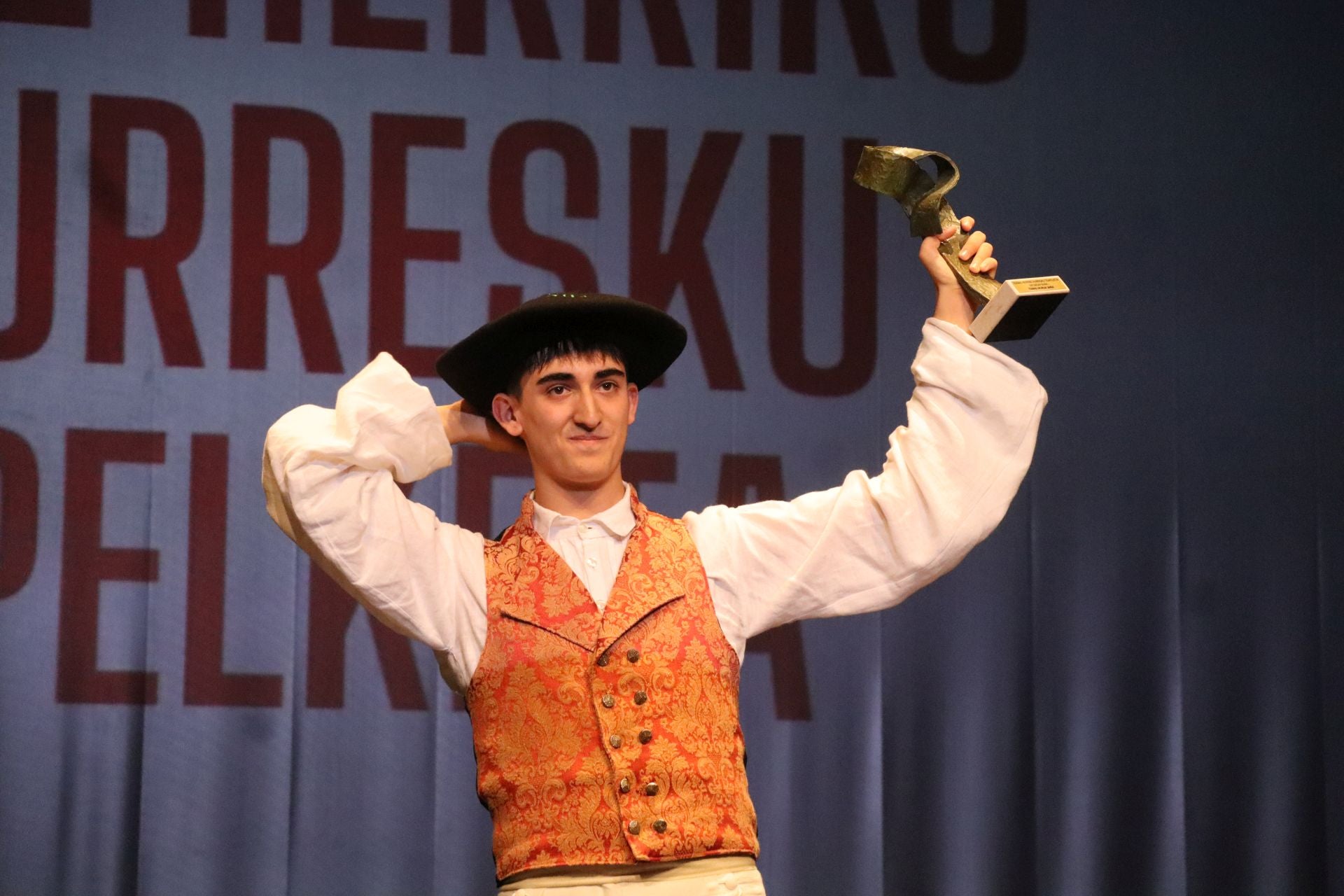 Mikel Esnaola lezoarra, txapela buruan eta trofeoa eskuan.