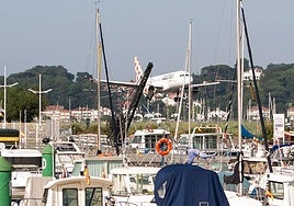 Un avión en el aeropuerto de Hondarribia junto a un grupo de barcos.