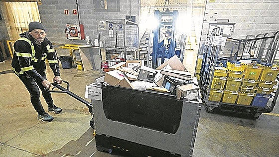 Un operario desplaza una de las cajas con paquetería voluminosa que descargó el trailer.