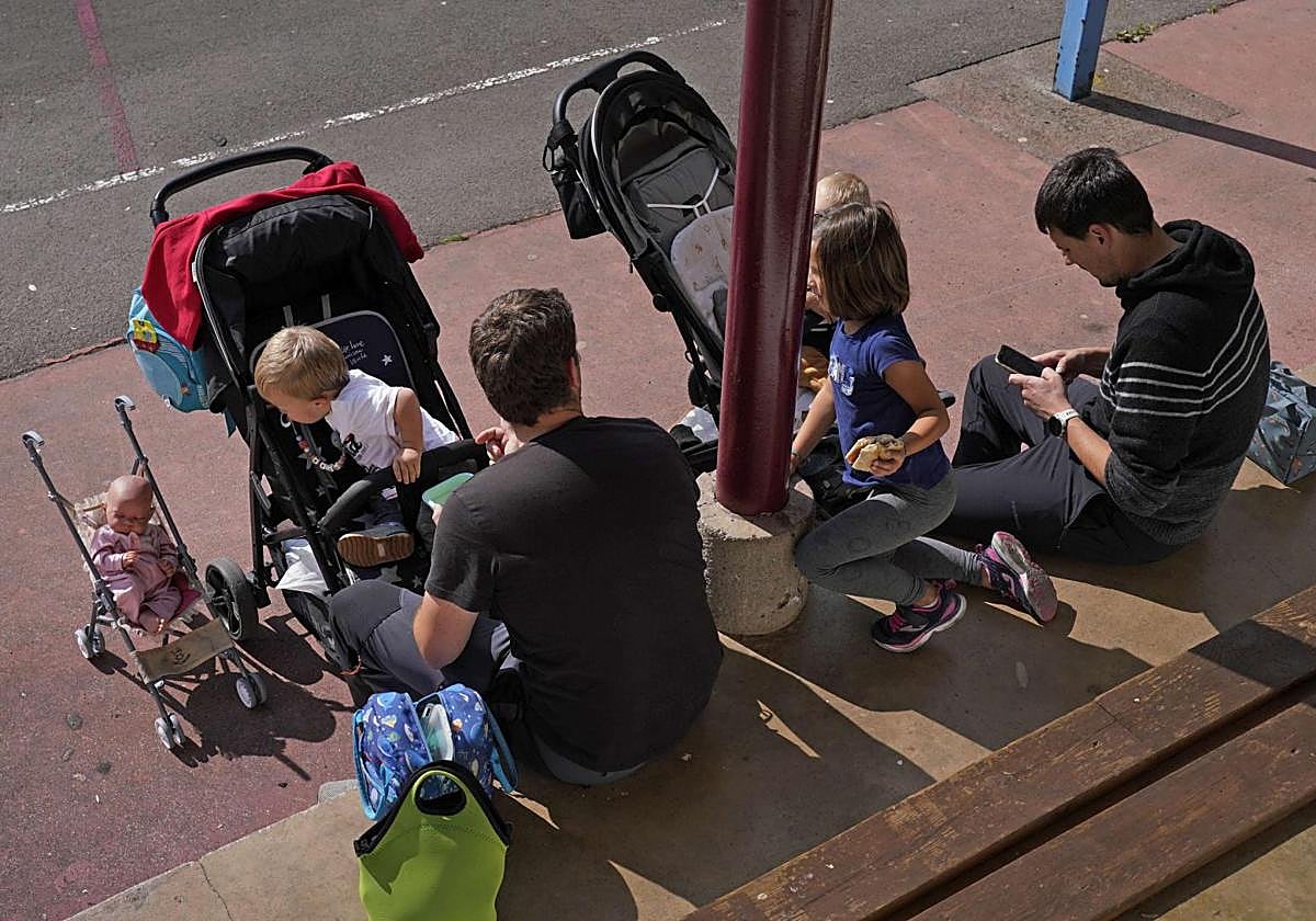 Dos padres ccuidan de sus hijos de corta edad.