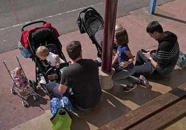 Dos padres ccuidan de sus hijos de corta edad.