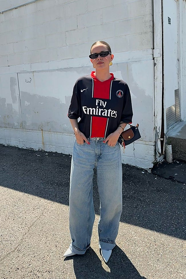 La combinación de camiseta 'oversized' con pantalones vaqueros, 'stilettos' y bolso pequeño nos encanta.