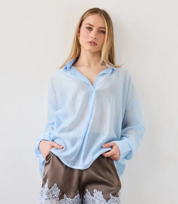 Camisa azul de lino y pantalón corto lencero marrón.