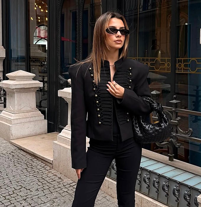 Chaqueta napoleónica negra, pantalones capri y bolso negro.