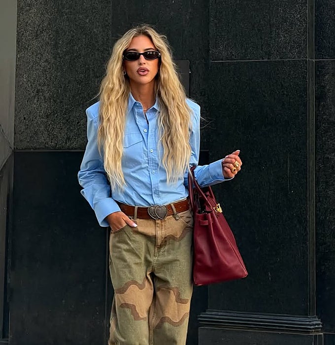 Camisa azul, pantalón militar y bolso granate.