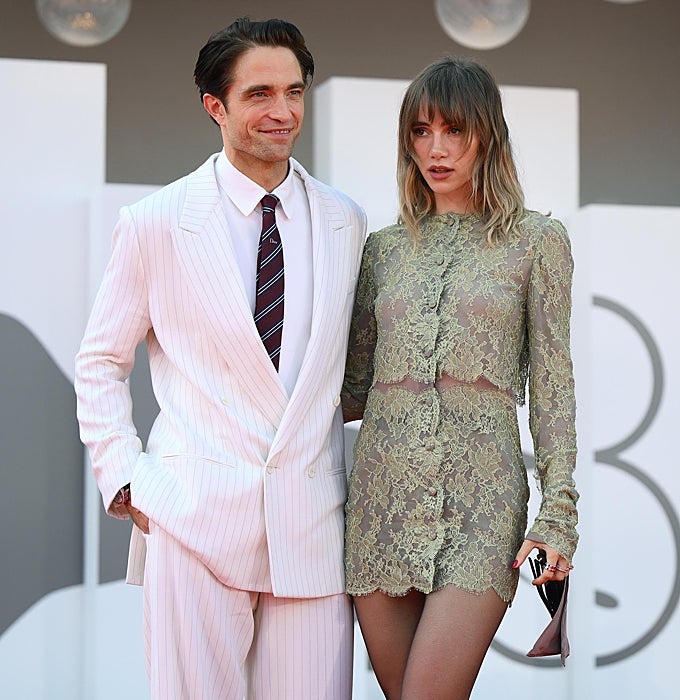 Robert Pattinson, de traje blanco de Dior, junto a Suki Waterhouse con vestido de encaje de Saint Laurent.