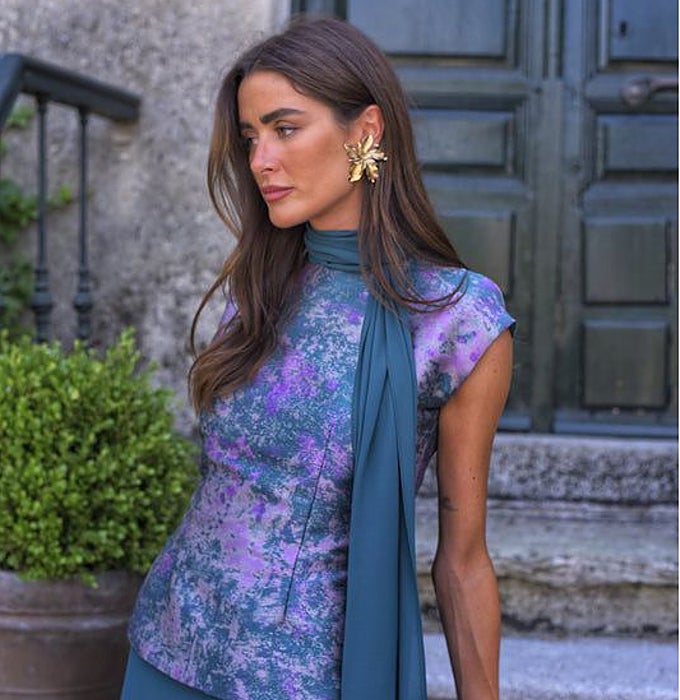 Top estampado en tonos malva y azul, combinado con falda lisa en azul teja y un fular a juego.