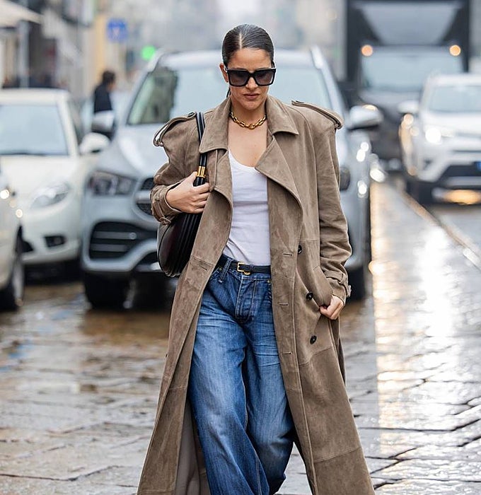 Gabardina larga con solapas 'maxi' en marrón, 'denim', 'top' blanco, bolso y gafas negras.