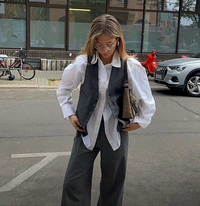 Camisa blanca, chaleco sastre y pantalón de traje gris.