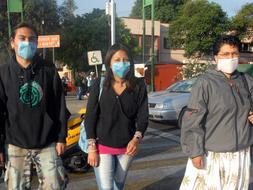 Ciudadanos se protegen con tapabocas en el marco de un brote de gripe porcina que afecta al país./ Efe