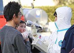 Operacios desinfectan a los viandantes de una posible radiactividad. / Reuters