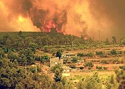 Las llamas se aproximan a un conjunto de viviendas en la localidad valenciana de Turis. / Foto: Manuel Bruque (Efe) | Vídeo: Atlas