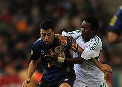 Busquets pelea un balón con el nigeriano Emenike Emmanuel. / Lluis Gene (Afp)