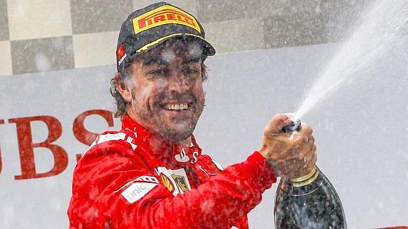 Alonso baña con champán a sus compañeros de equipo.
