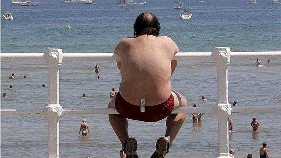 Un hombre observa el mar en Gijón. 