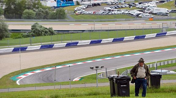 Un hombre camina delante del circuito de Austria. 