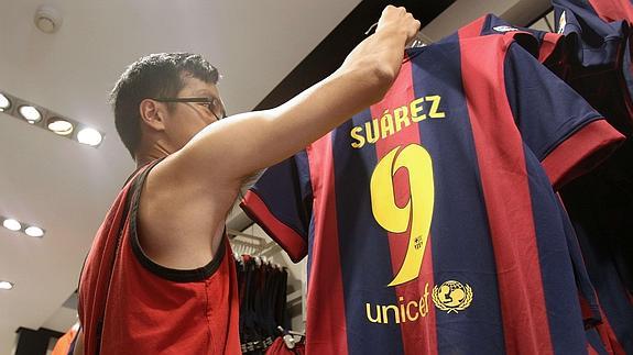 Un aficionado del Barça compra la camiseta de Luis Suárez. 