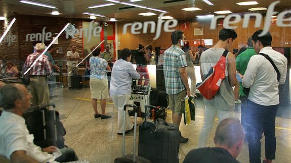 Pasajeros haciendo cola en atención al cliente de Renfe. 