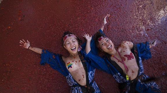 Dos asistentes disfrutan de la Tomatina de Buñol (Valencia). 