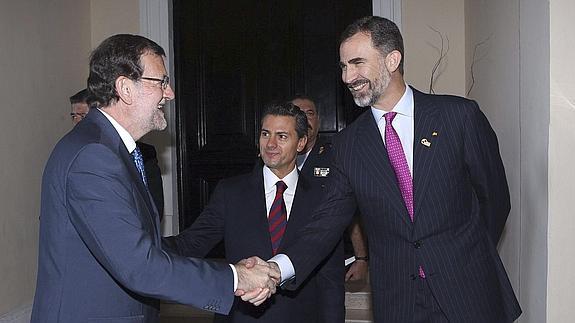 El rey Felipe VI saluda al presidente del Gobierno español, Mariano Rajoy (i). 