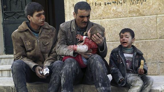 Un padre y sus tres hijos, supervivientes de un reciente bombardeo de las tropas leales al presidente Asad en la ciudad de Alepo. 