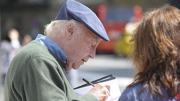 Eduardo Galeano firmando uno de sus libros.