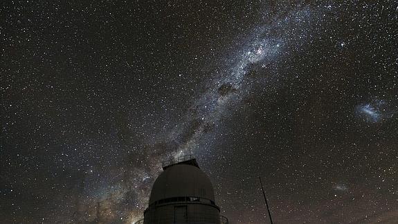 La Vía Láctea ilumina el firmamento, sobre un observatorio astronómico.