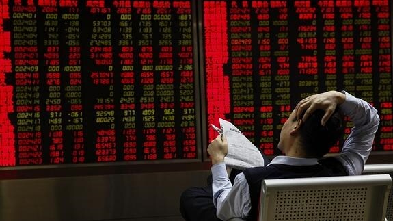Inversores observan la información bursátil en una correduría en Pekín. 