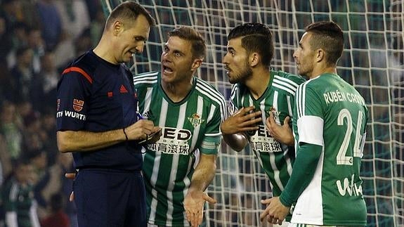 Varios jugadores del Betis protestan al árbitro. 