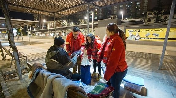 Voluntarios de Cruz Roja ayudando a indigentes.