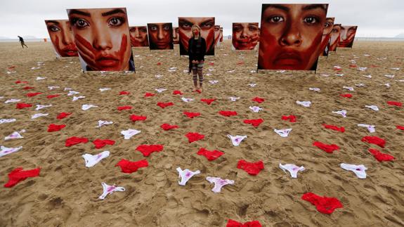 Cientos de bragas rojas y blancas (manchadas de sangre) tiradas en la arena de la playa de Copacabana.