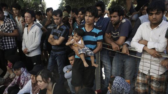 Un grupo de refugiados espera ante un comisaría de la isla griega de Kos.
