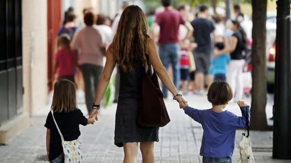 Una madre lleva a sus hijos al colegio en Valencia