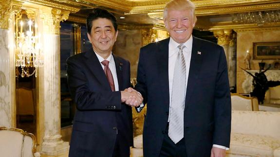 Donald Trump saluda al primer ministro japonés.