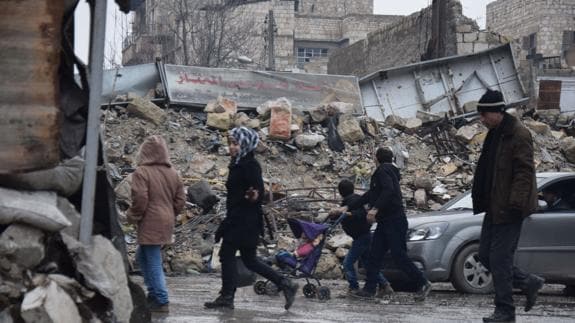 Una familia entre las ruinas de un barrio del este de Alepo en diciembre. 