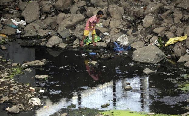 Un niño pesca en un río contaminado en Bombay (India). 