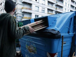 Un niño deposita cartones en el contenedor correspondiente. [FRAILE]
