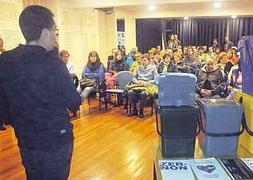 Andoni, con los cubos en primer plano y la alta asistencia presente en la sala al fondo. ::                             JUANFER
