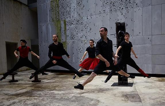 Cinco de los bailarines de Kukai, junto a la escultura 'Akelarre' de Néstor Basterretxea.